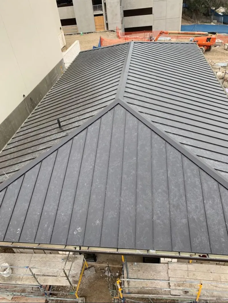 Commercial metal roof construction with crane equipment in Centerville